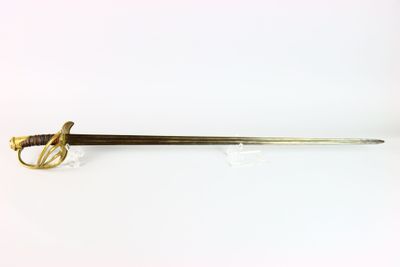 une vieille épée avec un manche en or sur fond blanc