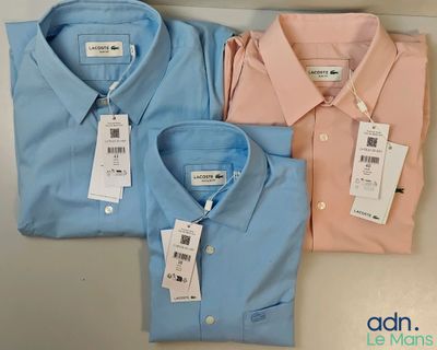 trois chemises pour homme, avec leurs étiquettes, posées sur une table