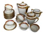 beaucoup d'assiettes, de tasses et de soucoupes blanches et dorées