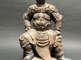 an old statue of a man sitting on a rock with a dog