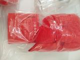 two red gloves in a plastic bag on a table