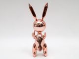 a small copper rabbit figurine sitting on its hind legs