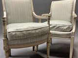 deux chaises blanches dont les accoudoirs et les pieds sont recouverts d'un tissu rayé