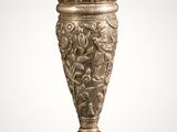 an antique silver vase with a bird on top of it