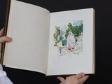 a person holding an open book with a picture of a woman on it
