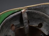 a close up of a helmet with a green hat on it