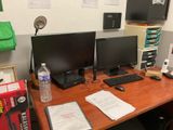 a desk with two computer monitors and a keyboard on it