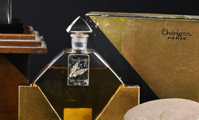 a bottle of perfume sitting next to a box of rocks