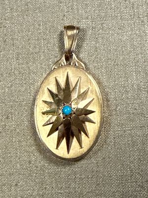 a silver and gold locke with a blue stone in it