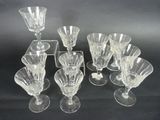 six clear glass wine glasses and a tray on a black background