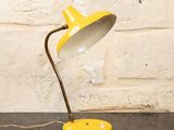 une image représentant une lampe de table jaune posée sur une table noire
