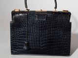 un sac à main en cuir de crocodile noir sur fond blanc