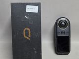 une image représentant un appareil photo et une boîte posés sur une surface blanche