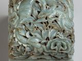 a green box with a dragon and flowers on it