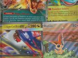 Plusieurs cartes Pokémon sont disposées sur une table devant une fenêtre.