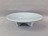 a white plate on a stand on a gray background