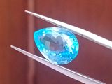 une image représentant un diamant bleu tenu par une paire de pinces
