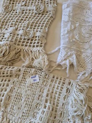several crocheted bags are laid out on a bed