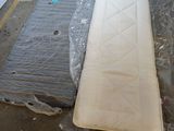 deux matelas posés à même le sol dans un entrepôt