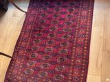 a rug on the floor next to a bed in a room