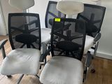 Trois chaises de bureau sont posées sur un parquet en bois massif, devant un mur blanc.