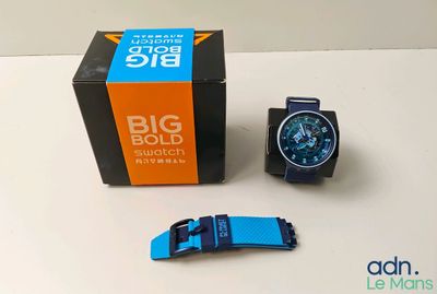 a blue and black watch sitting next to a black and orange box