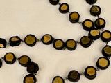 a black and gold necklace on a white table
