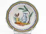 une assiette sur laquelle sont représentés un oiseau et un vase