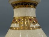 a white and gold vase with a cross on it