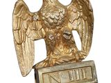 a gold eagle with a crown on it ' s head