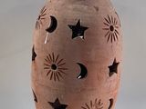 a brown vase with a star and moon design on it
