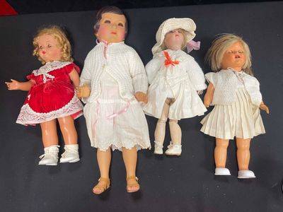 five dolls that are lined up on a black surface