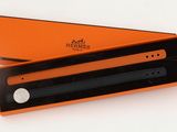 an orange box with a black pen inside of it on a white surface
