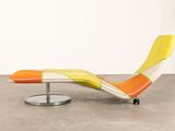 an orange and yellow chaise lounger sitting on a metal stand