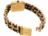 a close up of a gold and black bracelet on a white background