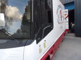 a red and white bus that is parked in front of a building