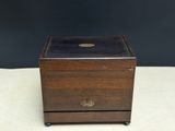a small wooden box with a brass plate on top of it