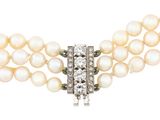 a three strand pearl necklace with a diamond clasp