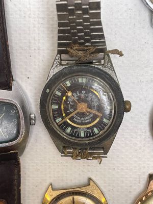 many different types of watches displayed on a table