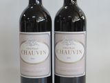 two bottles of red wine sitting next to each other on a table