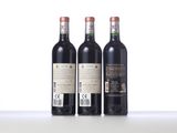three bottles of wine are lined up on a table