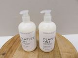 two bottles of olaplex 4 in 1 lotion sitting on a wooden tray