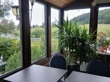 des tables et des chaises dans une pièce donnant sur un champ
