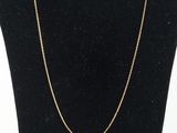 a gold chain necklace on a mannequin neck