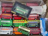 plein de petits bus dans une boîte posée par terre