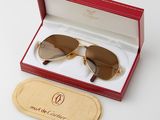une boîte contenant une paire de lunettes de soleil, posée sur une surface blanche