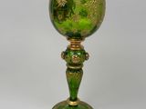 green and gold goblet sitting on a white surface