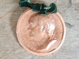 a penny with a green ribbon on top of it