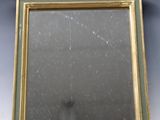une image représentant un miroir avec un cadre doré et un décor de feuilles