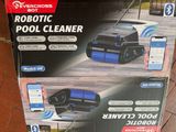 une boîte contenant un robot nettoyeur de piscine posée par terre